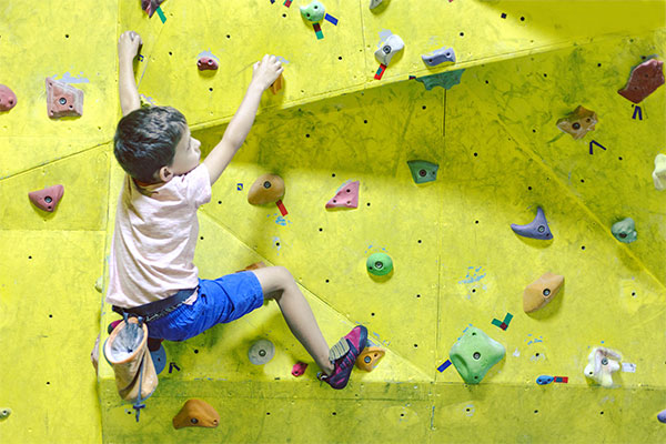 young child on indoor rock climbing wall