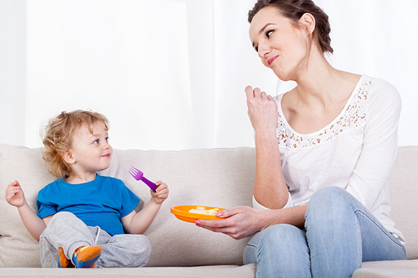 Mom and child eating on a couch