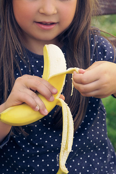 Child peeling banana