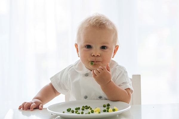 Toddler eating peas