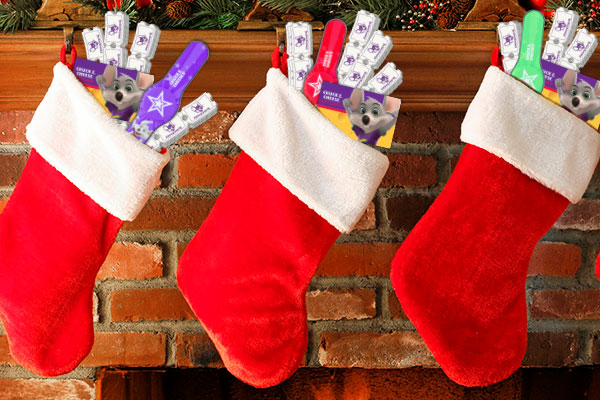 3 stockings hung by fireplace with chuck e cheese gift cards
