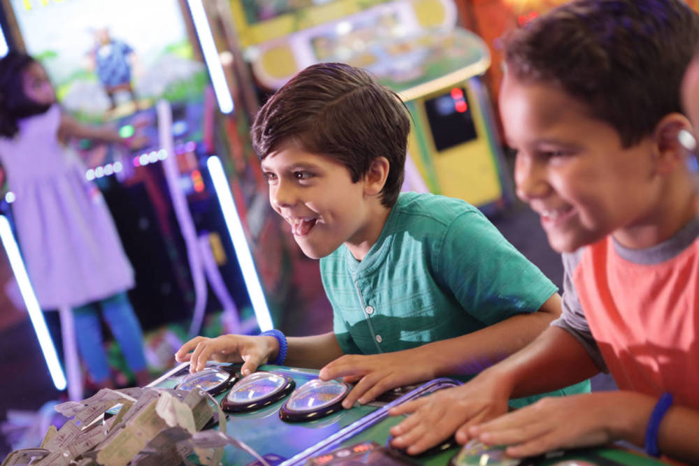 Two kids playing a game with a bundle of tickets in front of them