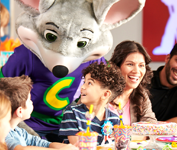 Kids celebrating at a birthday party with Chuck E. Cheese