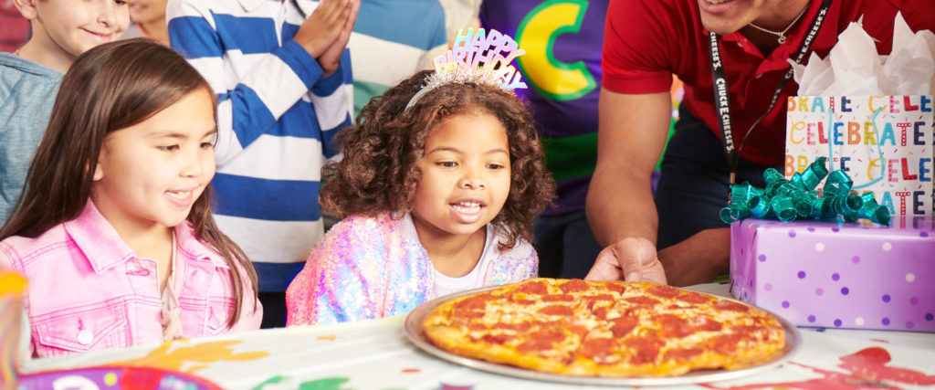 kids being served pizza at a birthday party