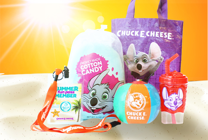 Fun pass and lanyard, bag of cotton candy, tote bag, inflatable beach ball and branded cup sitting together on sand. 