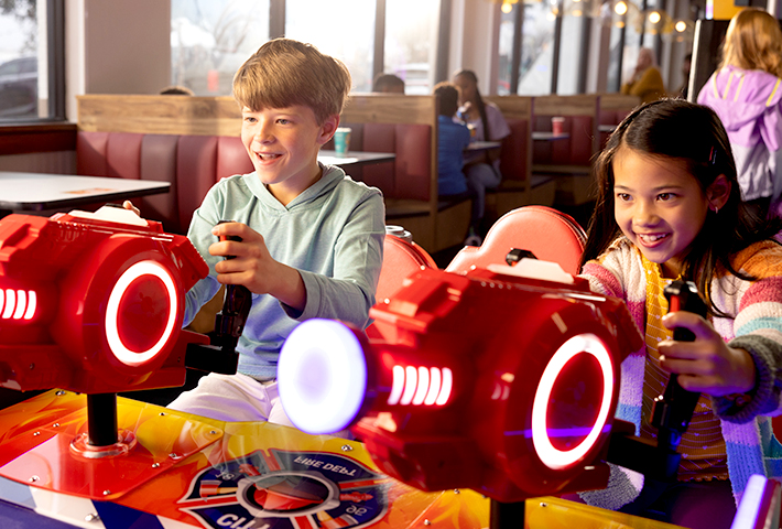 2 children playing interactive arcade game