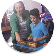 child and mom palay arcade game together
