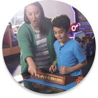 child and mom palay arcade game together