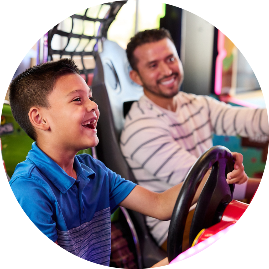 father and son racing in driving arcade game