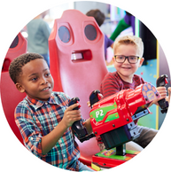 two young kids playing laser arcade game