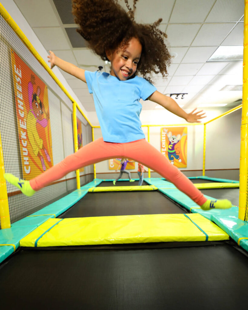 A kid at the height of a jump in the trampoline zone