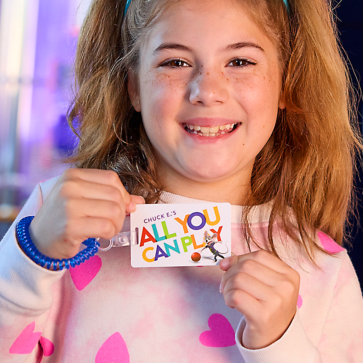 young child holding an all you can play game card 