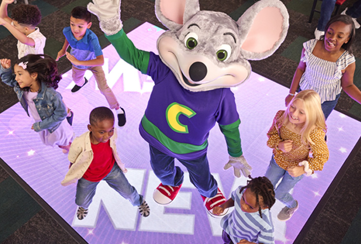 chuck e cheese on the dance floor with several kids