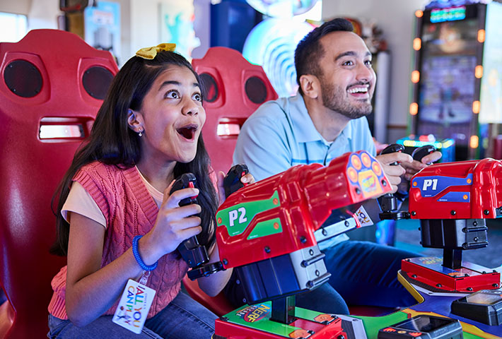 A parent and kid playing a blaster game