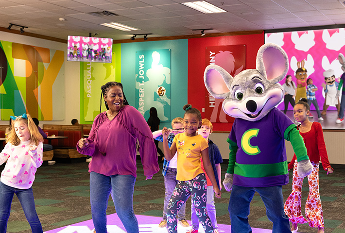 Kids and Mom dancing with Chuck E. on the dance floor
