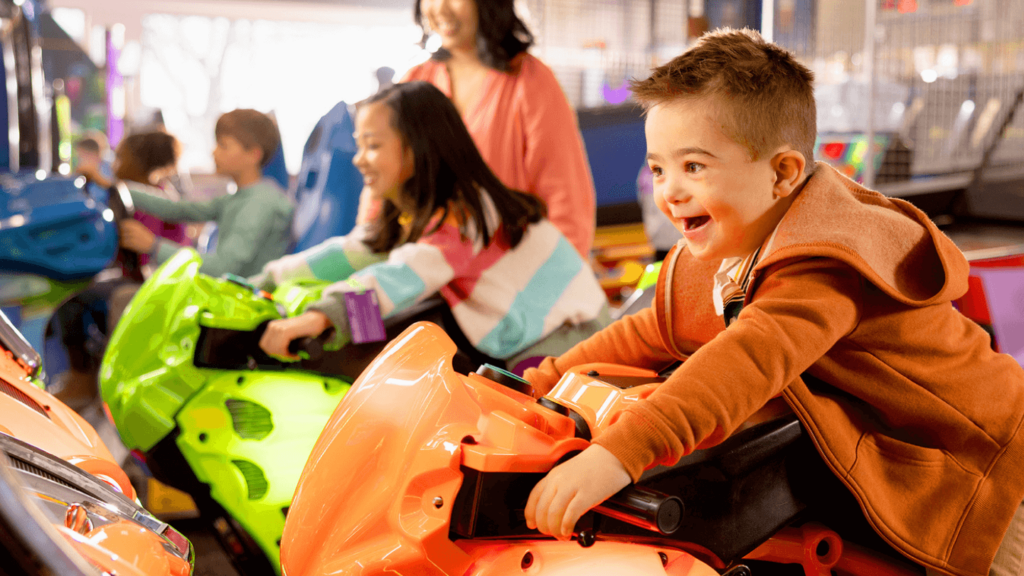 children playing a motorcycle arcade game