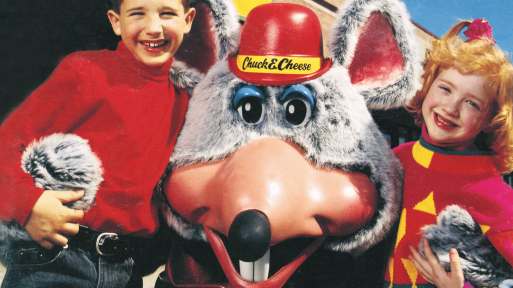 Boy and girl hugging Chuck E.
