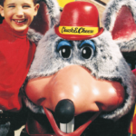 Boy and girl hugging Chuck E.