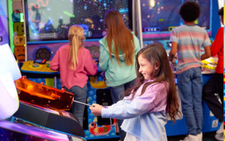 Girl playing arcade game.