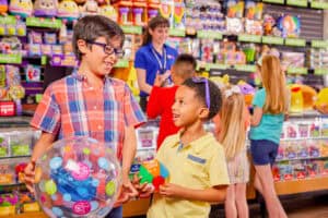young boys holding chuck e. cheese prizes