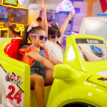 young girls with purple sunglasses playing arcade games