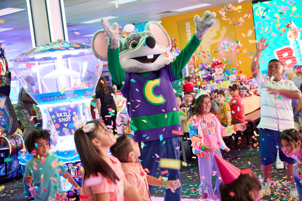 chuck e. cheese throwing confetti at kids birthday party
