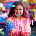 young girl at chuck e cheese birthday party holding confetti