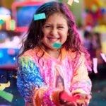 young girl at chuck e cheese birthday party holding confetti