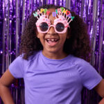 young girl wearing cupcake shaped happy birthday sunglasses