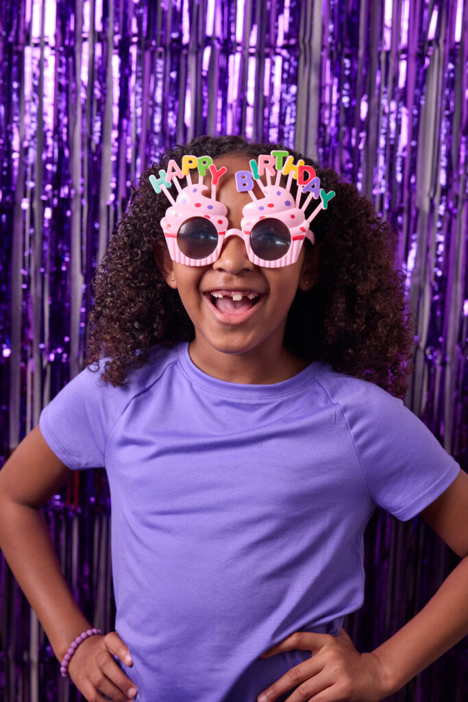 young girl wearing cupcake shaped happy birthday sunglasses