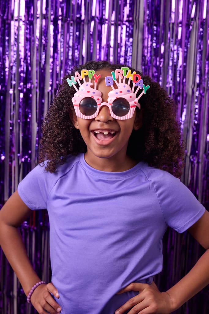 young girl wearing cupcake shaped happy birthday sunglasses