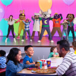 chuck e. cheese and munch's make believe band putting a show on stage with kids for families at chuck e. cheese