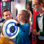 father with son and daughter playing arcade games