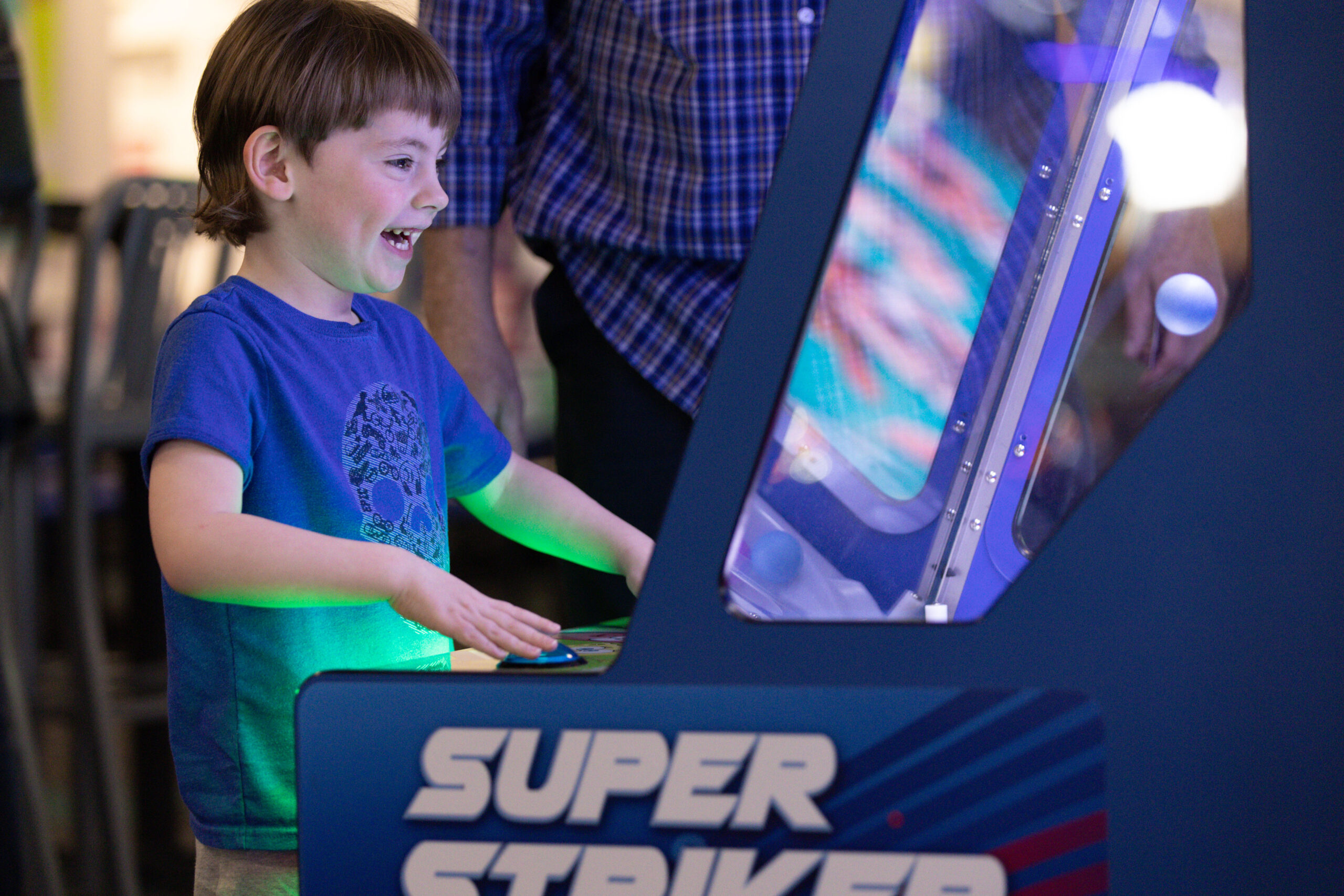 child playing arcade game with green light glowing