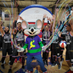 chuck e. standing with the harlem globetrotters