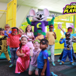 Children in superhero costumes with Chuck E. Cheese
