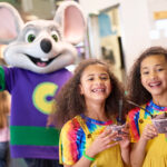 Children enjoying treats with Chuck E. Cheese.