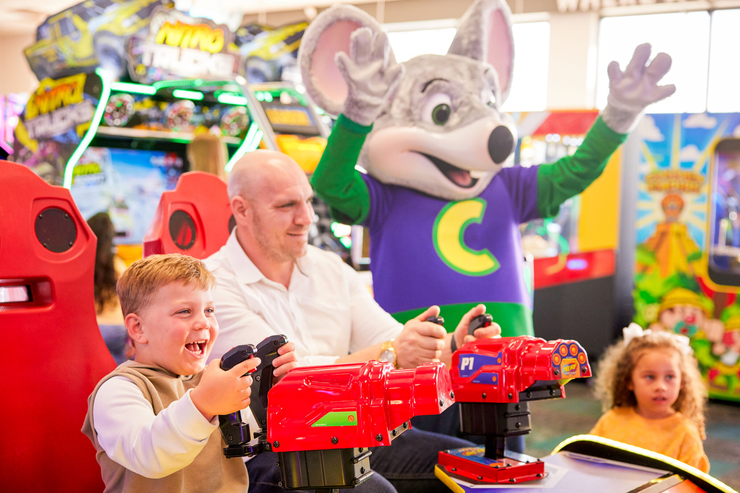 Child using a Fun Pass to play arcade games with family at Chuck&nbsp;E.&nbsp;Cheese
