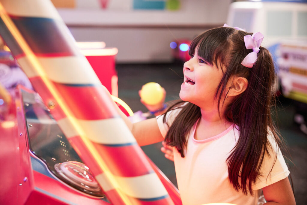 Young child focused on an arcade game at Chuck&nbsp;E.&nbsp;Cheese