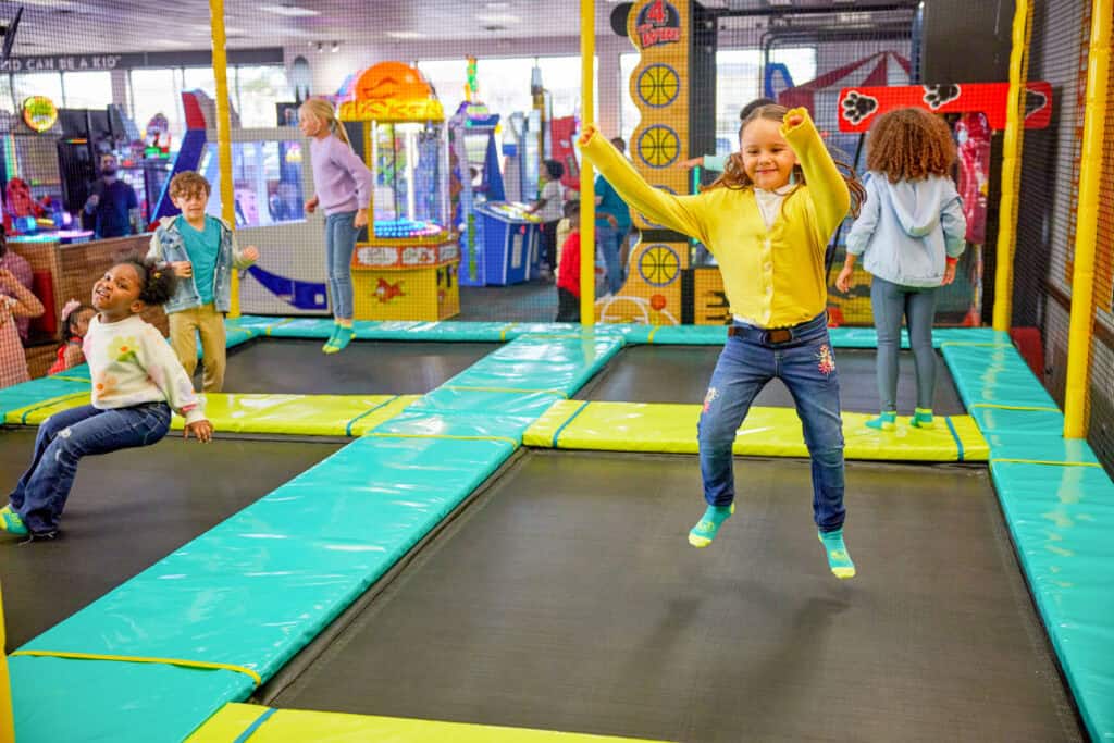 Kids jumping on trampolines at a Chuck E. Cheese birthday party