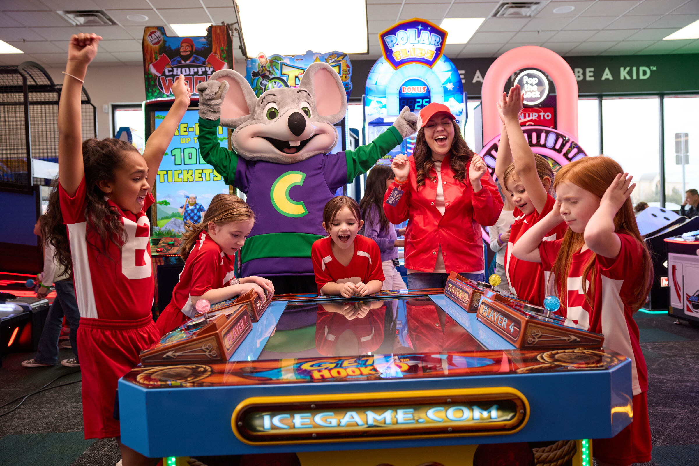 Kids in red soccer uniforms celebrate at Chuck E. Cheese, the ideal youth sports team party venue