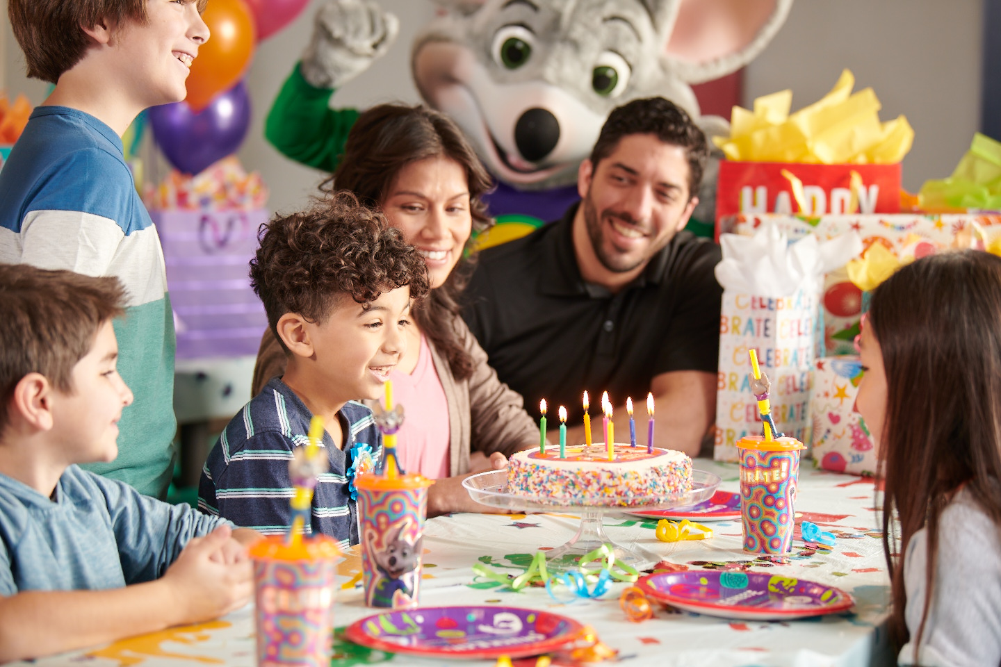 Kids and familie enjoying a birthday party at a Chuck E. Cheese location.
