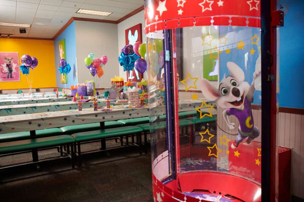 Chuck E. Cheese party room with balloons and tables set for a kids birthday