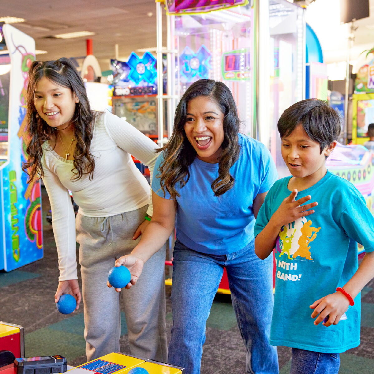 Family playing skeeball at Chuck E. Cheese arcade with Fun Pass