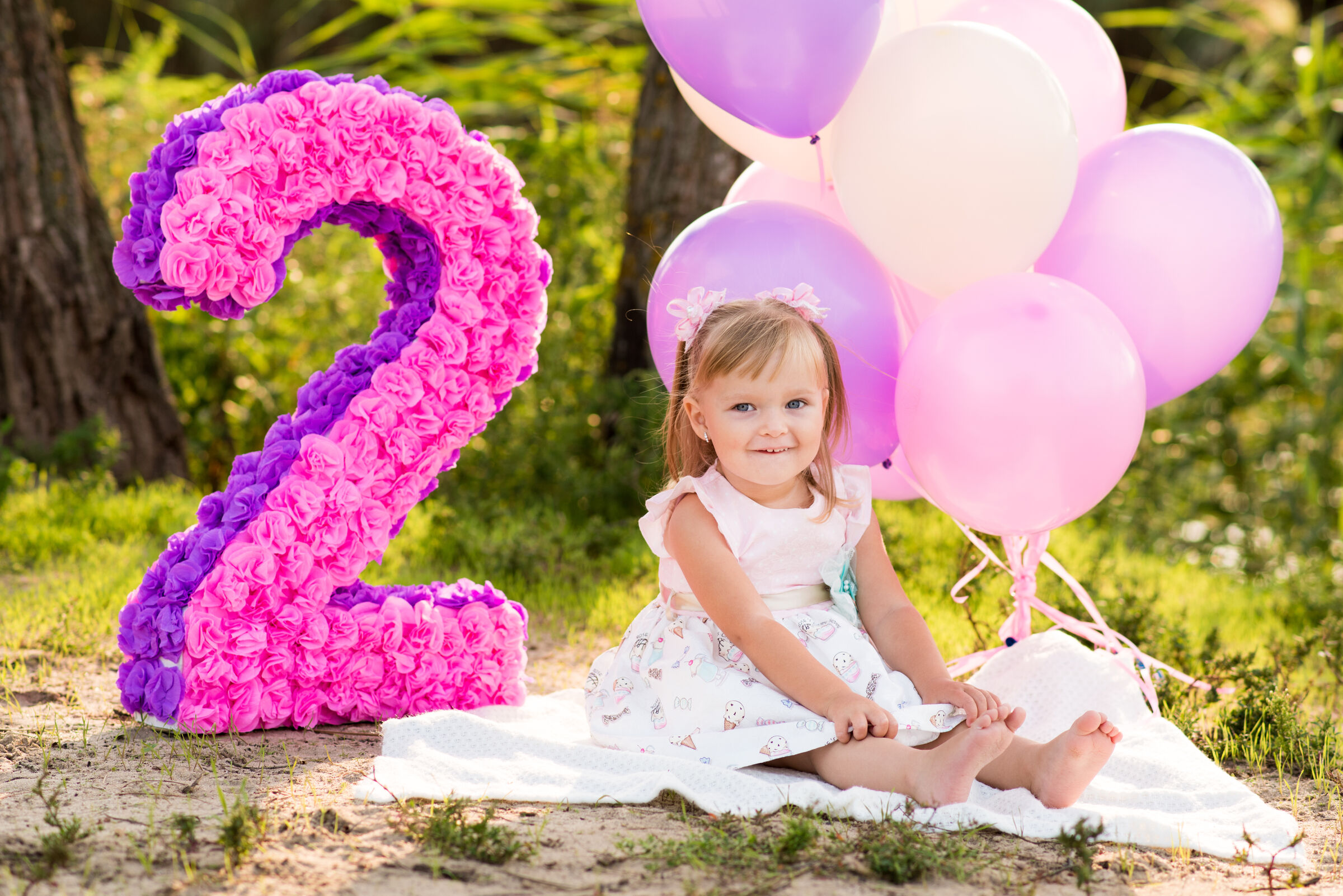 Large pink floral number-2 balloon and decor in a Chuck&nbsp;E.&nbsp;Cheese party room set up for a 2-year-old's birthday.