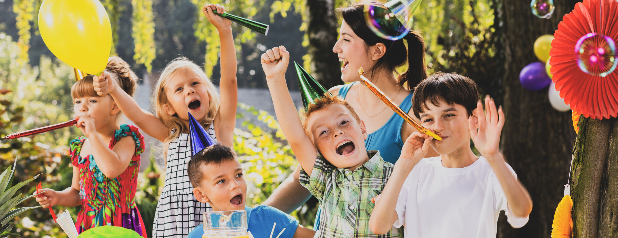 Group of smiling children at Chuck E. Cheese in a lively, fun party room setting