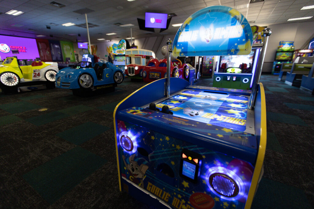 Chuck E. Cheese arcade floor with various games and ride-on cars, ready for guests at a Sensory Sensitive Sunday event.
