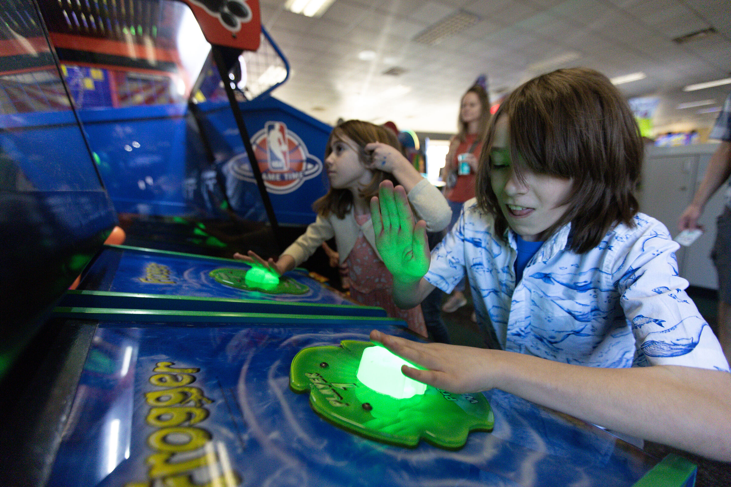 Kids playing a Frogger arcade game at Chuck E. Cheese during Sensory Sensitive Sundays