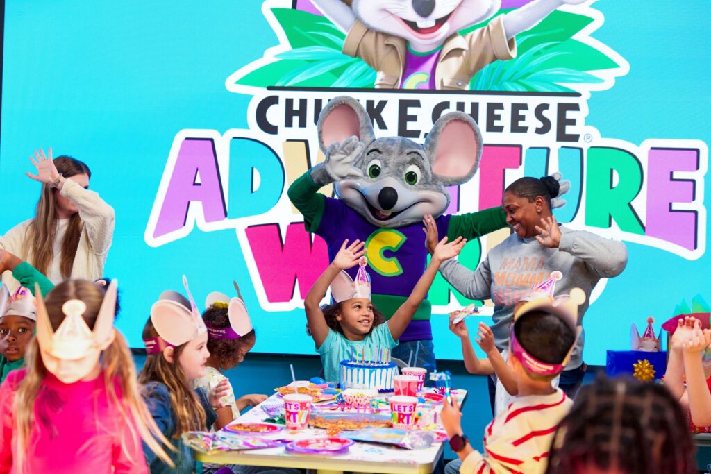 Young child in safety goggles catching tickets in the Ticket Blaster at Chuck&nbsp;E.&nbsp;Cheese.