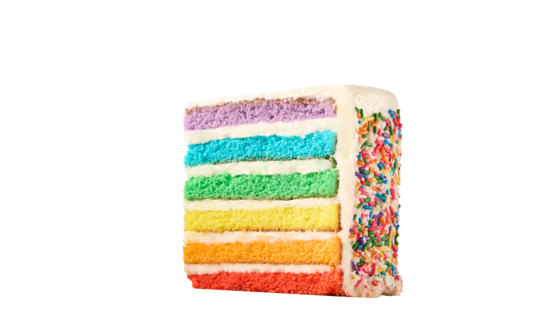 Rainbow layer cake slice with white frosting and sprinkles, birthday party treat at Chuck E. Cheese family fun center.
